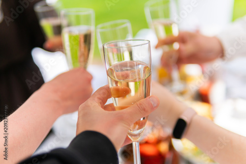 Hands clinking champagne glasses in a celebratory toast, festive moment, close-up