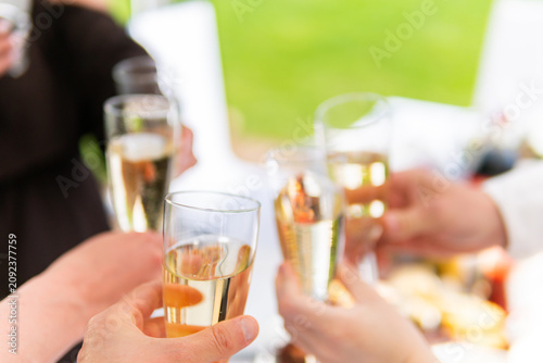 Hands clinking champagne glasses in a celebratory toast, festive moment, close-up