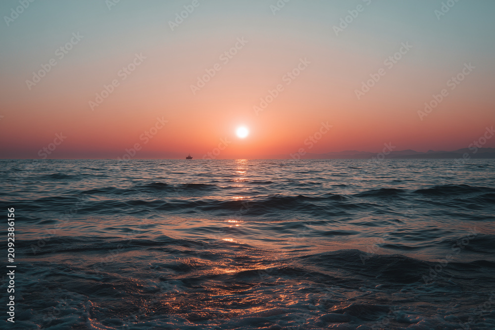 Fototapeta premium Warm sunset over the sea capturing a peaceful summer vacation lifestyle