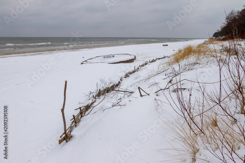 Fotografie Snowy beach and dunes by the winter sea