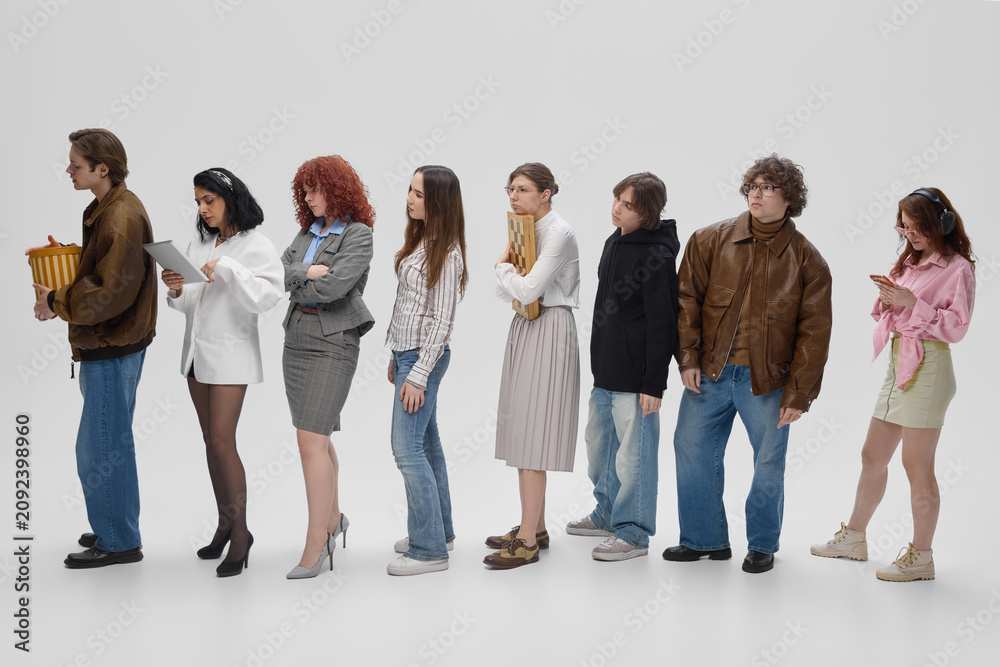 Obraz premium Diverse shoppers waiting in checkout line with bags and purchases in modern retail store. Concept of retail sales, shopping rush, customer flow, consumer demand and checkout service.