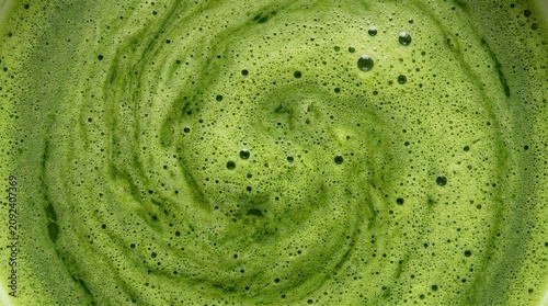 Green matcha tea featuring creamy microfoam, ultra macro full-frame texture, rich frothy surface, natural patterns, premium Japanese beverage