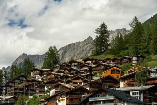 Zermatt, switzerland mountain village houses perched on a hillside with alpine backdrop