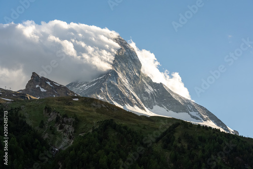 Cuadro en lienzo Matterhorn mountain with clouds passing over its snowy slopes and green hills be