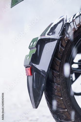 Принти на полотні Closeup of a motorcycle rear tire and mudguard during a rainy day, showing the t