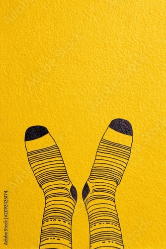 closeup of feet in socks, drawing on a yellow background