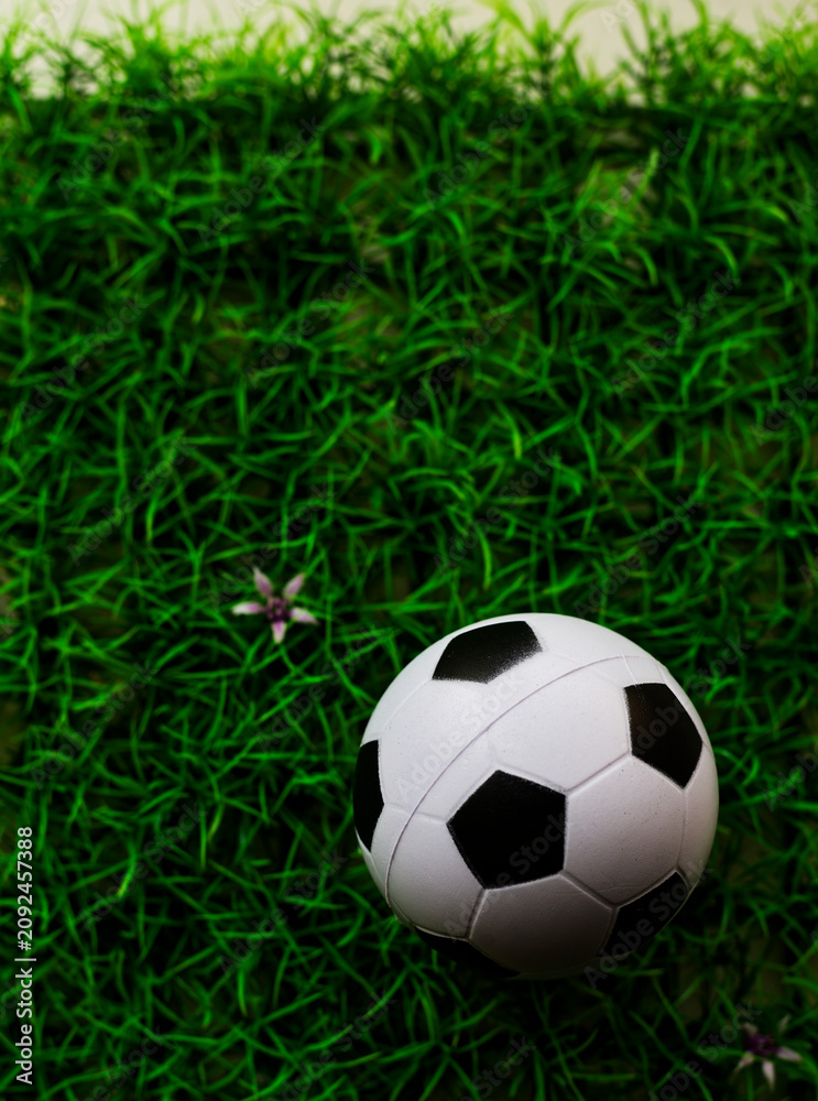 Fototapeta premium Soccer Ball on Artificial Turf: Overhead View of Classic Black and White Football on Vibrant Green Synthetic Field