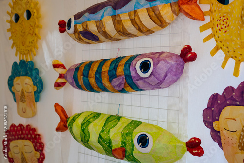 Handmade colorful fish wall decorations displayed at an artisan market stall.
