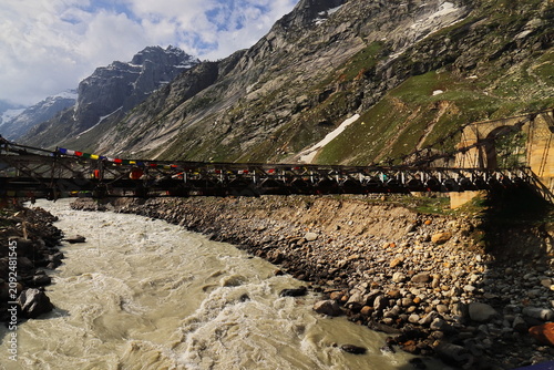 old cable stayed bridge over chandra or chenab river, scenic mountain landscape of chhatru campsite area of hampta pass trek, explore himalayas, lahaul valley in himachal pradesh, india