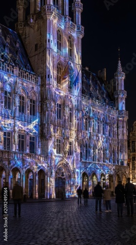 Light projection mapping on historical European building facade at night.