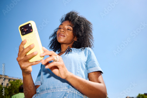 Beautiful woman uses her phone on a sunny day
