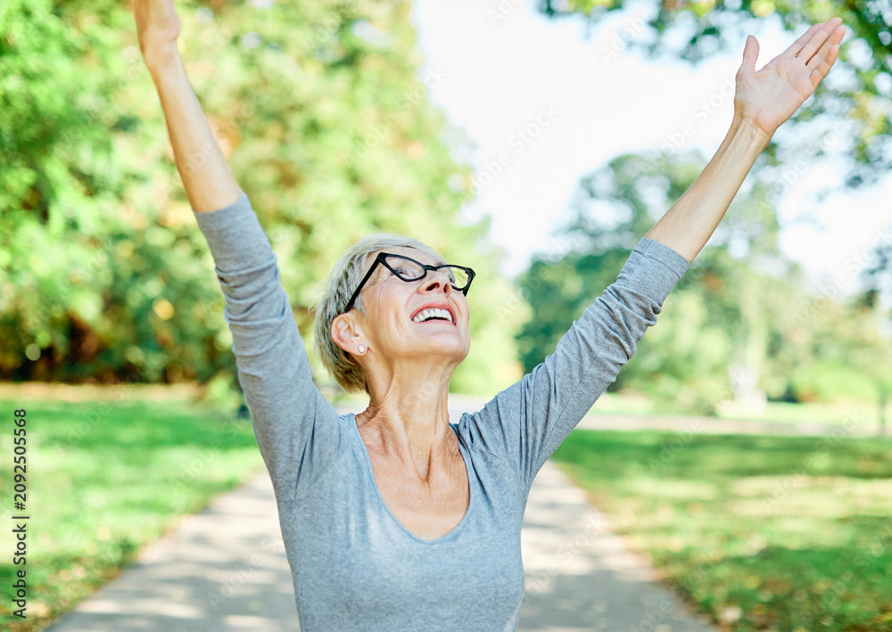 Fototapeta premium Happy active senior woman meditating and daydreaming and relaxing and nature outdoors