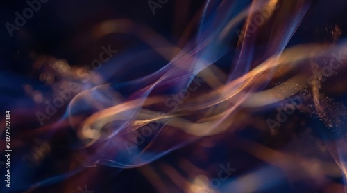 Abstract orange and blue glowing light trails.