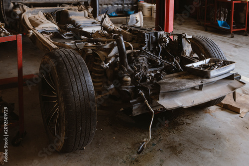 Disassembled Car Chassis with Engine Repair in Automotive Workshop Garage