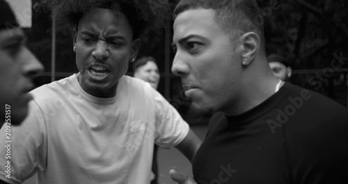 Tableau sur toile Heated argument between two men of Latin and African descent on outdoor basketba