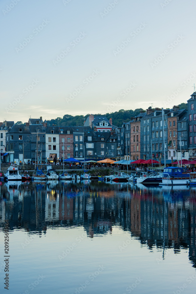 Fototapeta premium Beautiful reflection of traditional slate houses and boats on calm water in the historic harbor of Honfleur, Normandy, France. Picturesque travel background.