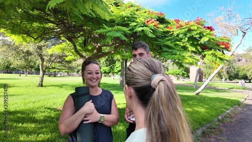 A group of friends chat happily after working out in the park