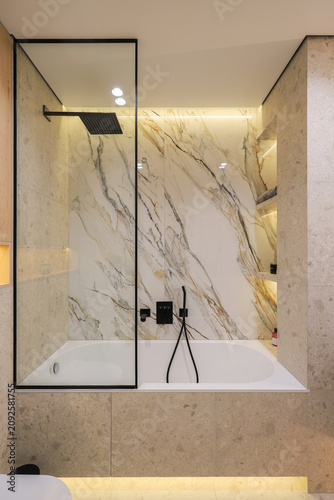 Modern bathtub with glass shower screen