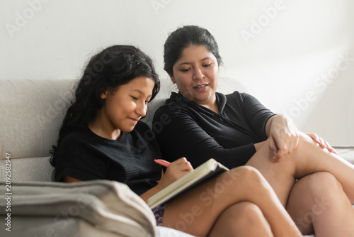 Foto Mother looking proudly at her daughter writing during a meaningful family moment