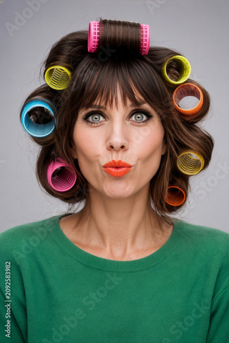 Frau mit bunten Lockerwicklern und orangefarbenen Lippenstift
