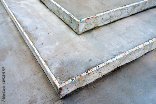 Abstract close up of modern grey concrete steps featuring a decorative terrazzo style edge with embedded colorful stone chips