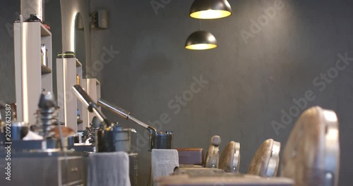 Camera is sliding right, revealing tufted chairs moving into foreground to showcase salon stations