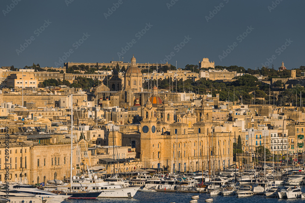 Fototapeta premium Charming historic streets and majestic architecture of Birgu (Vittoriosa), Malta. Admire the warm limestone facades, medieval defensive walls, and stunning waterfront marina views.
