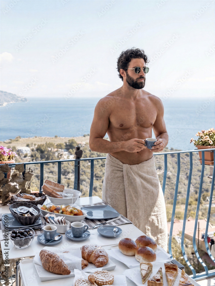 Fototapeta premium Man enjoying breakfast on a balcony overlooking the sea, wearing a towel and sunglasses, isolated on transparent background