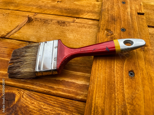 A close-up of the process of staining a natural wood table