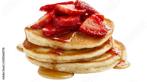 Stack of golden pancakes with sliced strawberries and maple syrup, isolated on transparent background