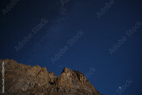 Canvas-taulu Breathtaking astrophotography of a starry night sky over a steep, rocky mountain ridge
