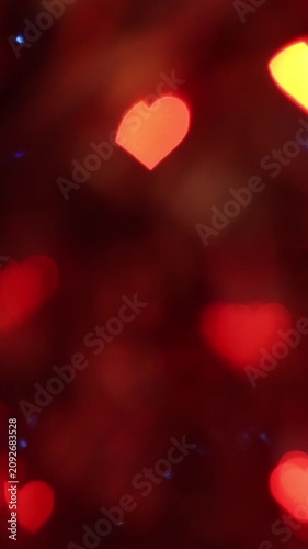 Soft abstract glowing red yellow heart-shaped bokeh light spots dark night background creating warm romantic festive atmosphere perfect Valentine's Day celebration wallpaper greeting cards design