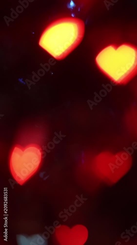 Abstract glowing red and yellow heart-shaped bokeh lights on dark night background, perfect for romantic festive atmosphere, Valentine's Day celebration, love, and greeting card design.