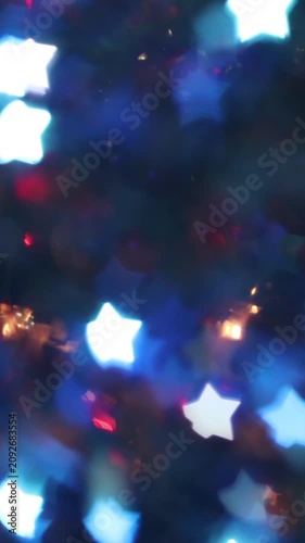 Glowing white and blue star bokeh lights on dark night background, festive winter holiday abstract decoration for Christmas New Year celebration greeting cards and banners.