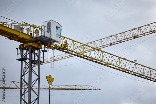 Photography Yellow tower crane cabin and jib on construction site background
