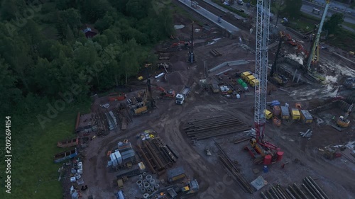 Wide drone panorama of industrial construction site with cranes excavators and concrete structures under development