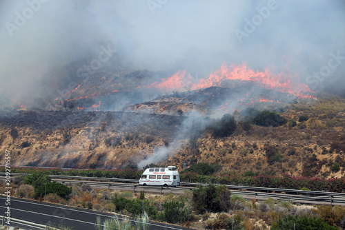 Bild auf Leinwand An ambulance races along a highway as a fast approaching wildfire threatens the vicinity of Los Gallardos in Almeria province in southern Spain amid an urgent emergency evacuation and rescue response