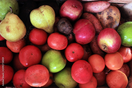 Variety of fresh fruits and root vegetables in a rustic box. Top view of organic apples, pears, mandarins and potatoes.