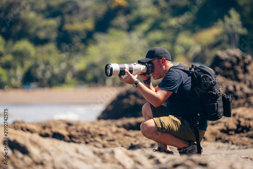 Foto Photographer with telephoto lens shooting nature on beach