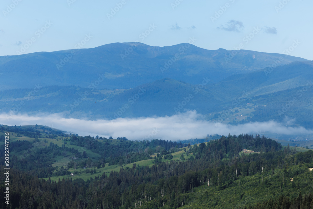 Obraz premium Beautiful foggy valley in Ukrainian Carpathians with rural village houses.