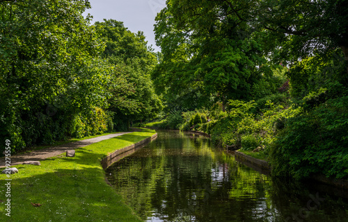 Vászonkép A tranquil view of the historic Llangollen canal in Chirk, Shropshire, UK, surrounded by verdant trees and reflecting the serene sky
