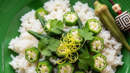 Gourmet okra in coconut rice with micro-cilantro and lime zest against fresh green negative space