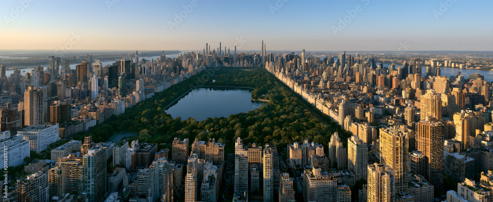Obraz premium A view of Central Park from above, in Manhattan, New York. The park is encircled by tall buildings. A stunning sight of the Jacqueline Kennedy Onassis Reservoir is visible in the park's center.