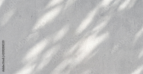 A textured surface with soft, subtle shadows creating a calming pattern. The light plays across the light gray background, adding depth and dimension.