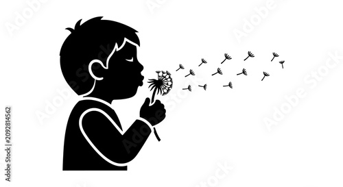 Black silhouette of a young boy blowing dandelion seeds into the air.
