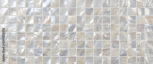 Iridescent mother of pearl mosaic tile texture with luminous square shell pattern creating a seamless luxury decorative background