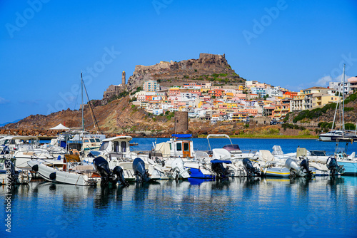 Small marina overlooked by the historic hilltop town of Castelsardo on the coast of the Mediterranean sea in Sardinia, Italy