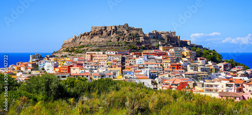 Historic castle ruins and colorful terraced houses in the hilltop town of Castelsardo, Sardinia, Italy