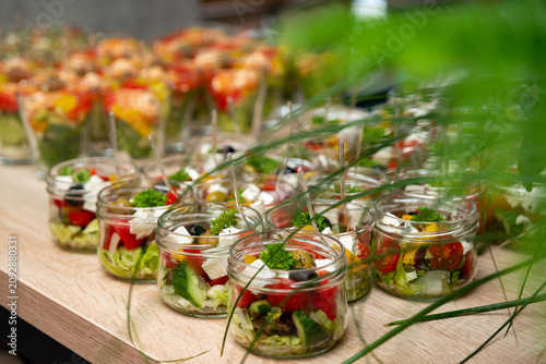 Fotografía Buffet table with colorful assorted salads and appetizers in transparent glass b