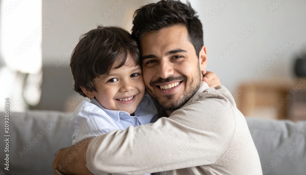Fototapeta premium Smiling father hugging young son warmly.